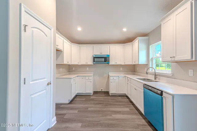 a kitchen with granite countertop white cabinets and white appliances