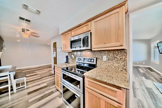 a kitchen with granite countertop a stove and a microwave
