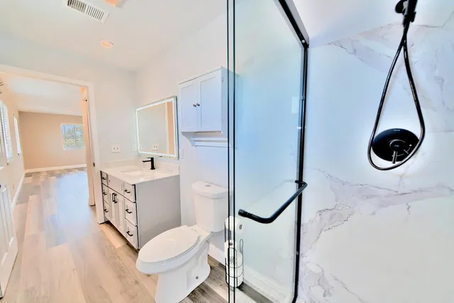 a bathroom with a sink a toilet and shower