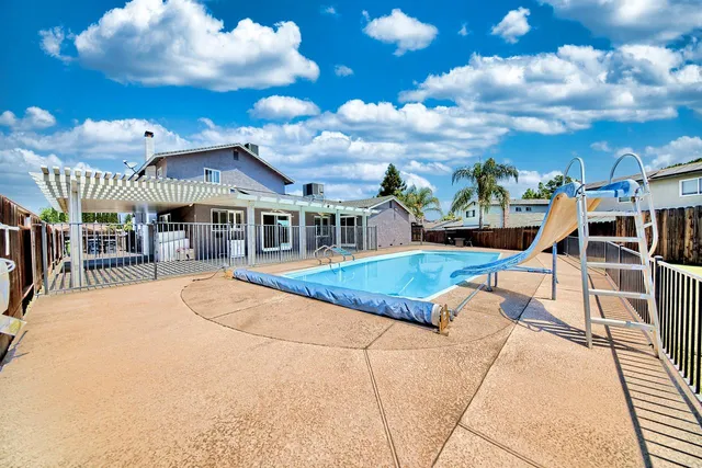 a view of a house with swimming pool and sitting area