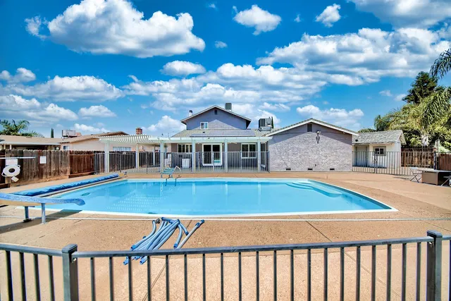 a front view of a house with swimming pool and sitting area