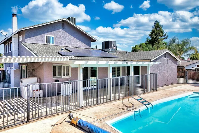 a view of a house with a patio and a yard