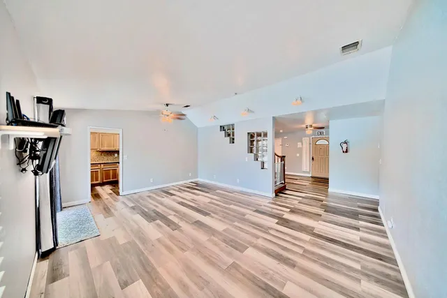 a view of a livingroom with wooden floor and a ceiling fan