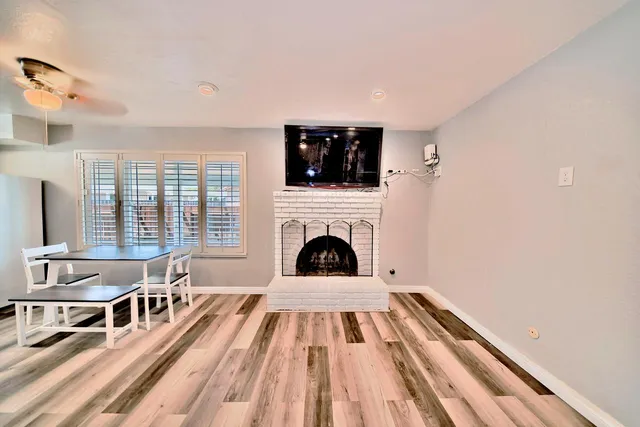 a view of a livingroom with furniture flat screen tv and floor to ceiling window