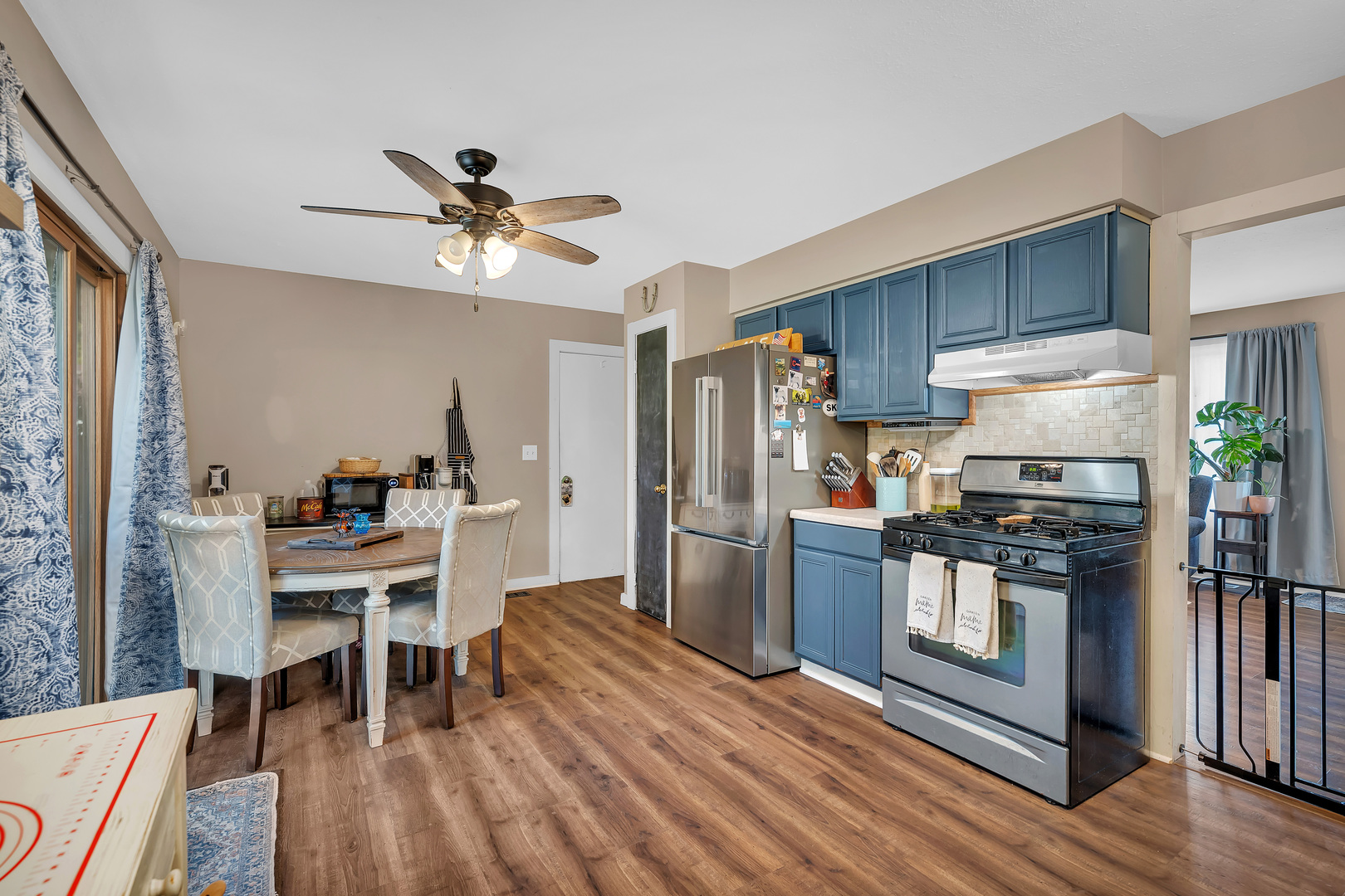 338 Orchard Lane Braidwood, IL 60408 - Photo 12 of 25 a kitchen with stainless steel appliances a stove a refrigerator a dining table and chairs with wooden floor