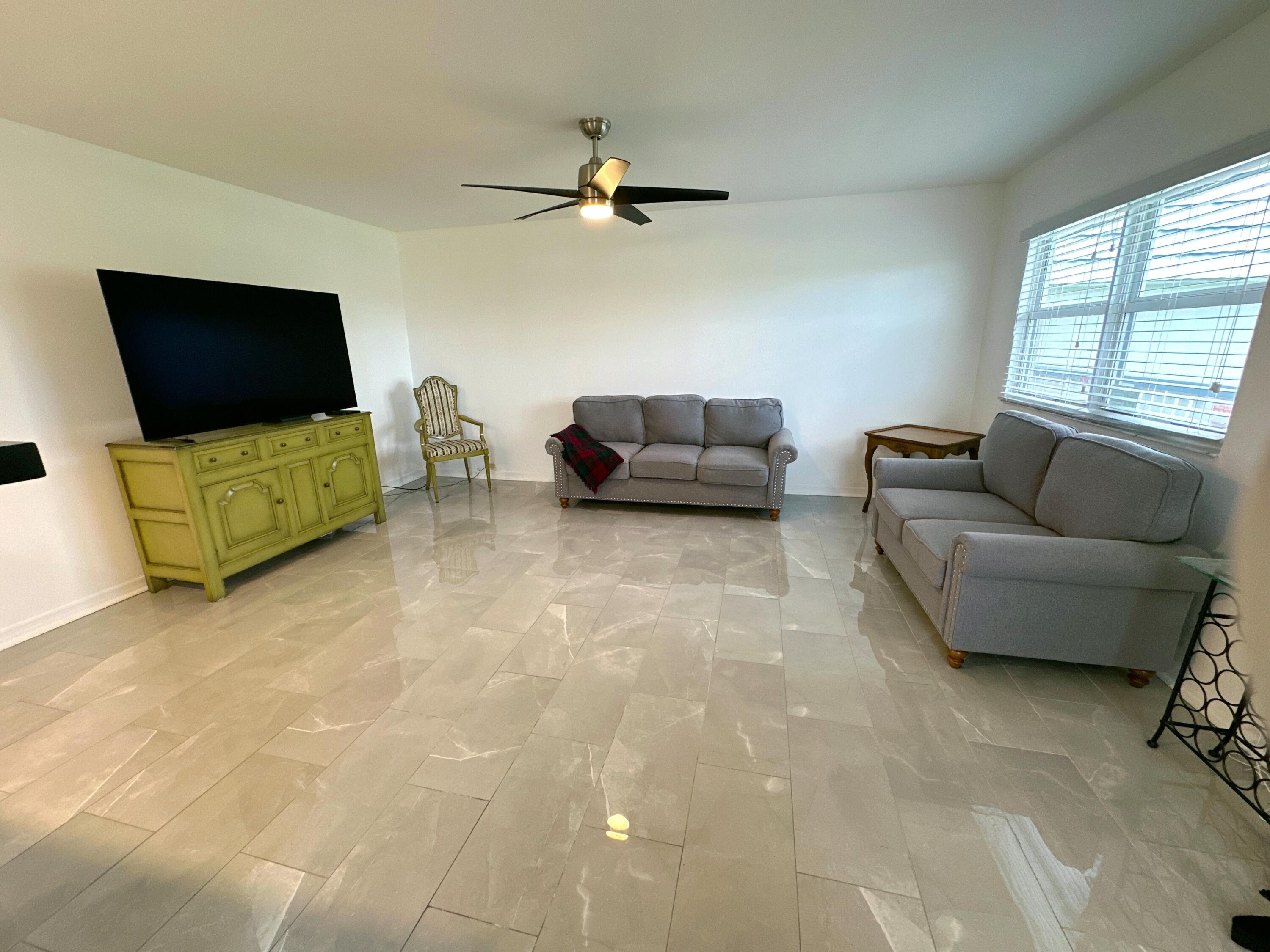 196 Tuscany C Delray Beach, FL 33446 - Photo 13 of 39 a living room with furniture and a flat screen tv