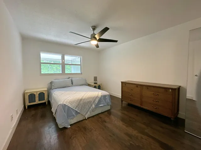 a bedroom with a bed and a ceiling fan
