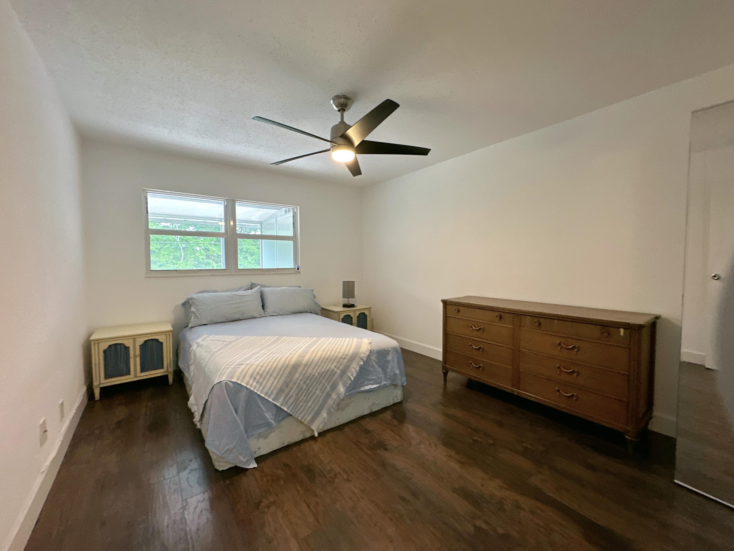 196 Tuscany C Delray Beach, FL 33446 - Photo 19 of 39 a bedroom with a bed and a ceiling fan