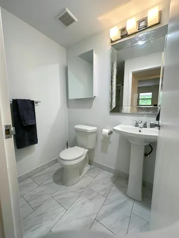 a bathroom with a toilet sink and mirror