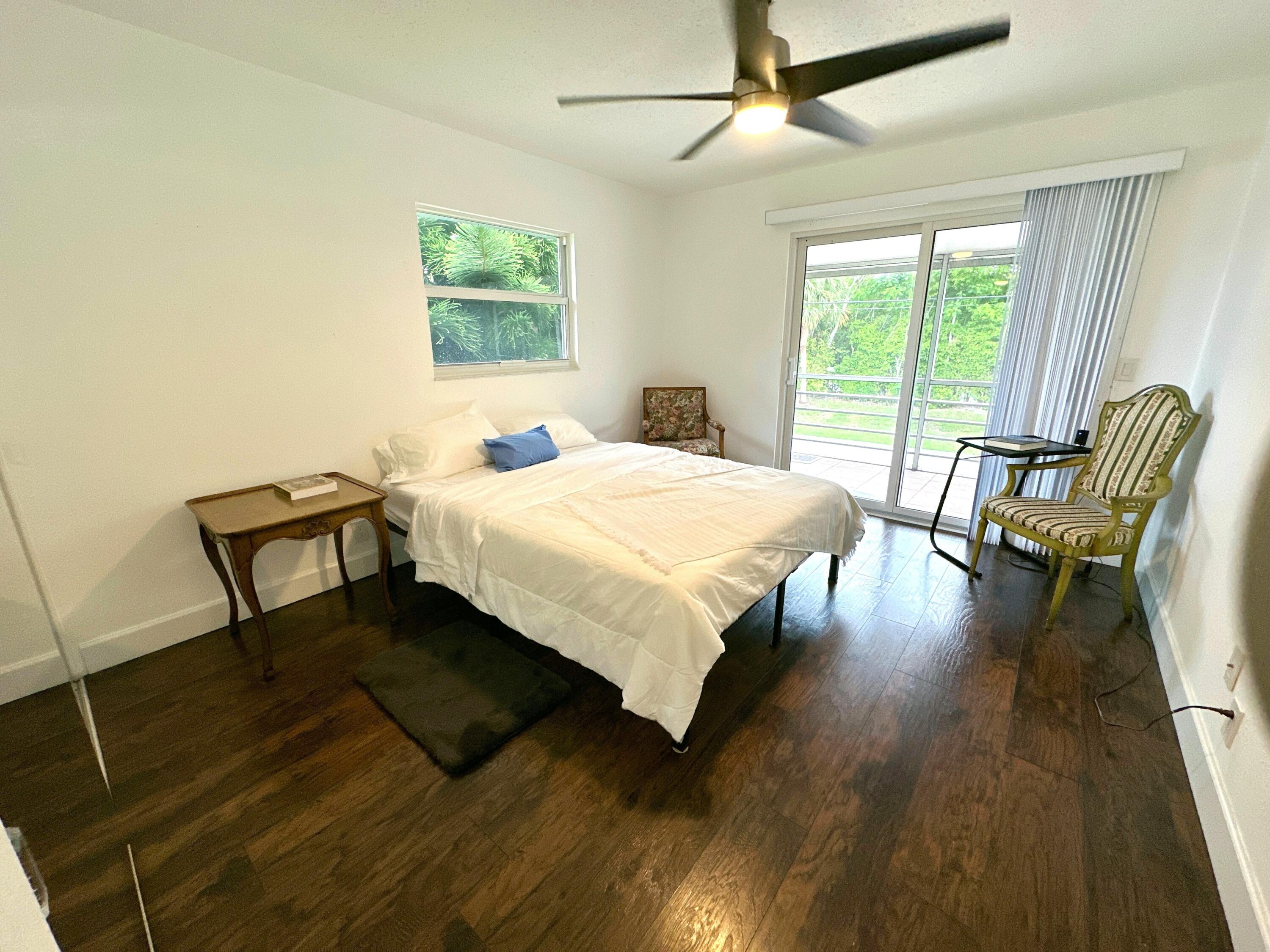 196 Tuscany C Delray Beach, FL 33446 - Photo 25 of 39 a bedroom with a bed a chair and a large window