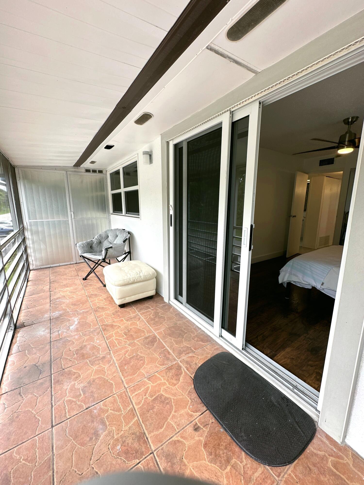 196 Tuscany C Delray Beach, FL 33446 - Photo 27 of 39 a view of a porch with furniture and front door