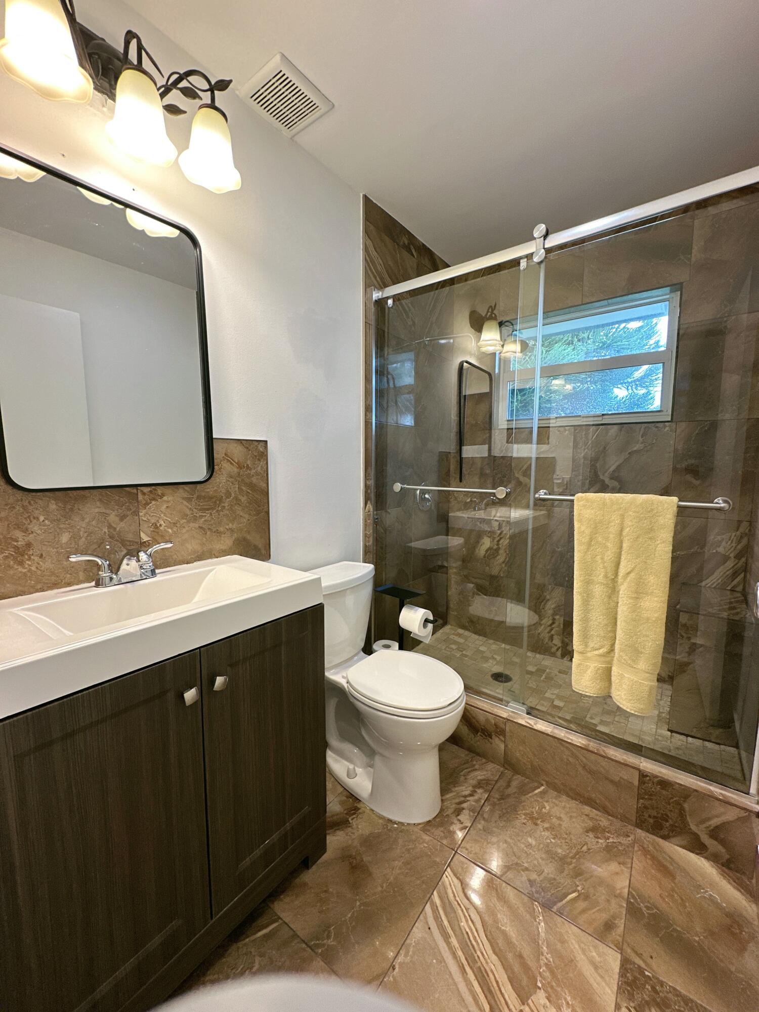 196 Tuscany C Delray Beach, FL 33446 - Photo 29 of 39 a bathroom with a sink toilet and shower