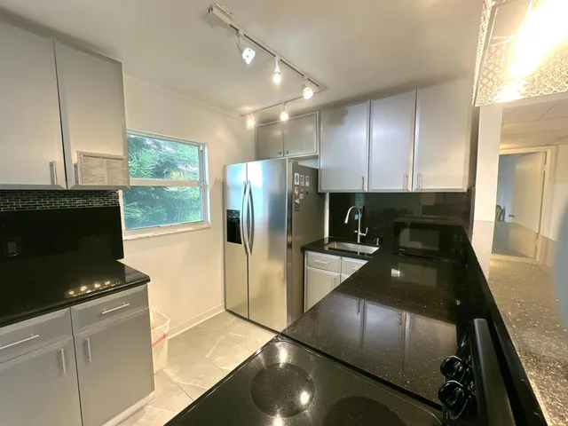a kitchen with stainless steel appliances granite countertop a refrigerator and a stove