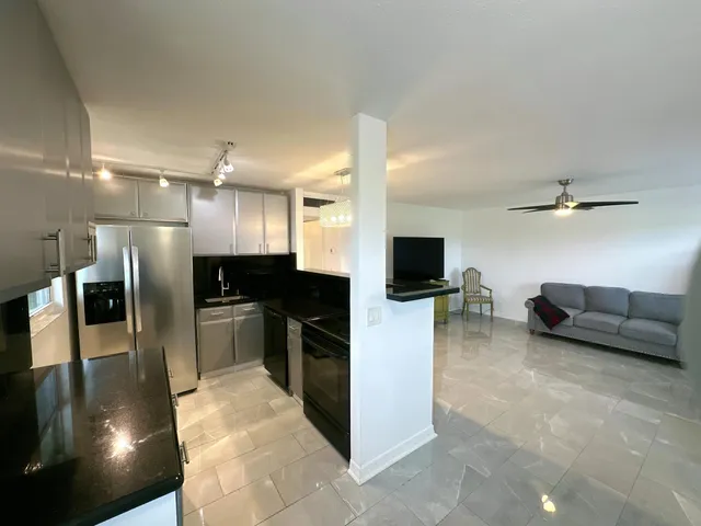 a view of living room kitchen and stainless steel appliances