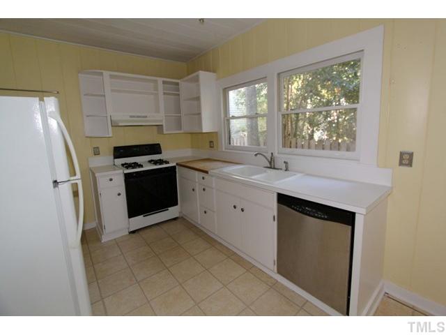 410 Chamberlain Street Raleigh, NC 27607 - Photo 5 of 14 a kitchen with stainless steel appliances granite countertop a stove a sink and a refrigerator