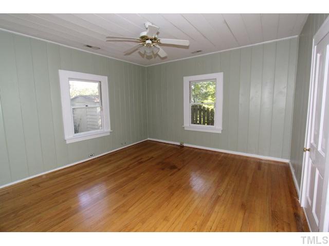 410 Chamberlain Street Raleigh, NC 27607 - Photo 6 of 14 a view of an empty room with wooden floor and a window