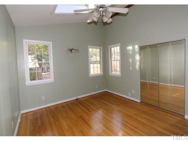 410 Chamberlain Street Raleigh, NC 27607 - Photo 7 of 14 a view of an empty room with wooden floor and a window