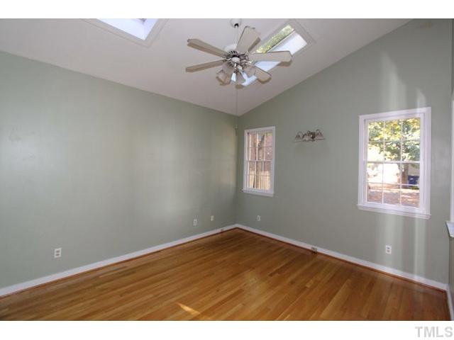 410 Chamberlain Street Raleigh, NC 27607 - Photo 8 of 14 an empty room with wooden floor and windows