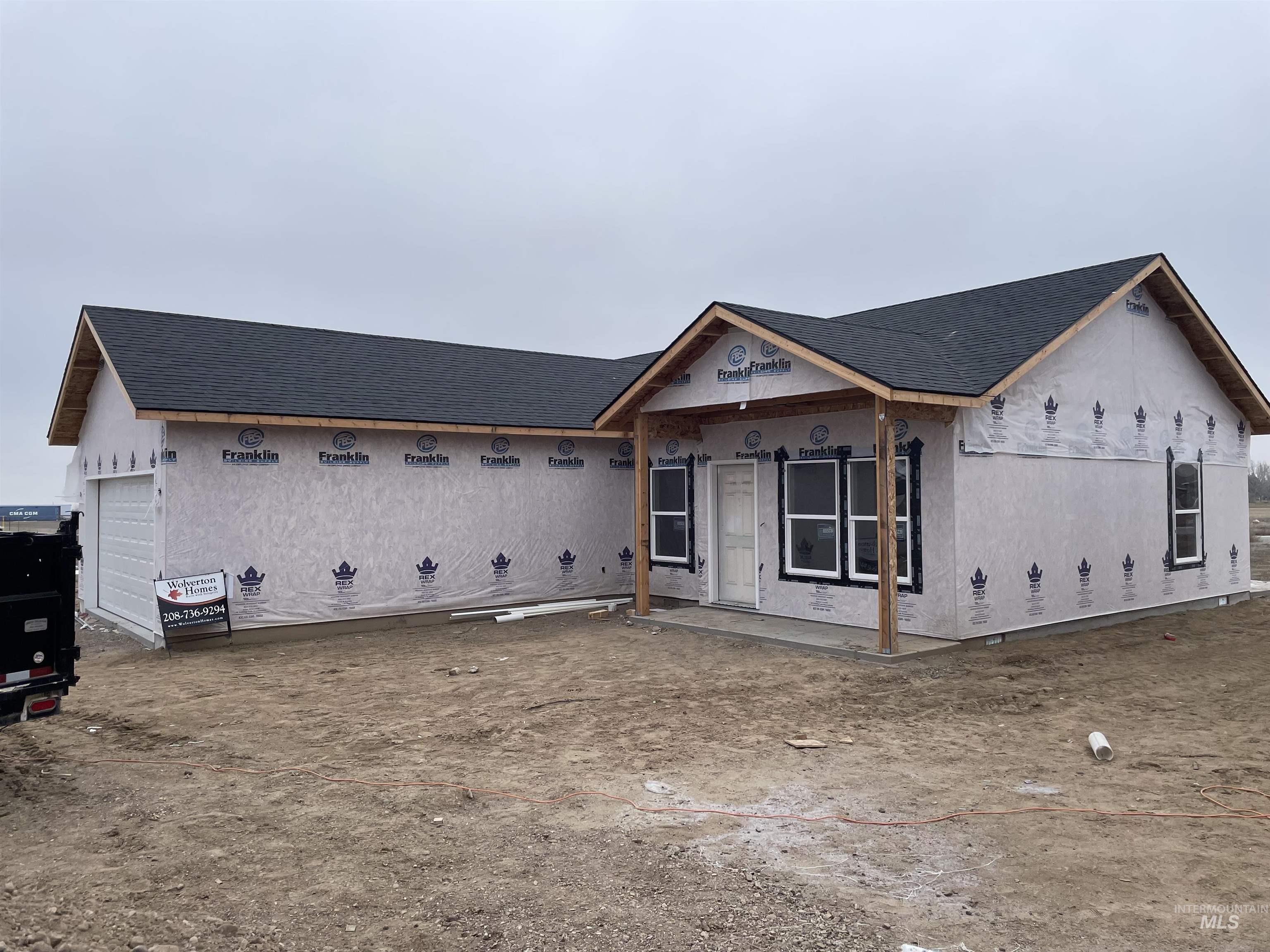 Unfinished property with roof with shingles, stucco siding, a garage, and covered porch