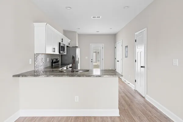 a kitchen with stainless steel appliances granite countertop a sink and refrigerator
