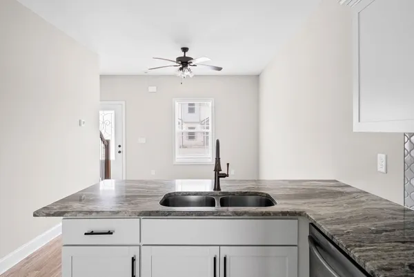a kitchen with stainless steel appliances granite countertop a sink and a refrigerator