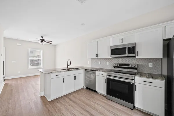 a kitchen with stainless steel appliances a white stove top oven and sink