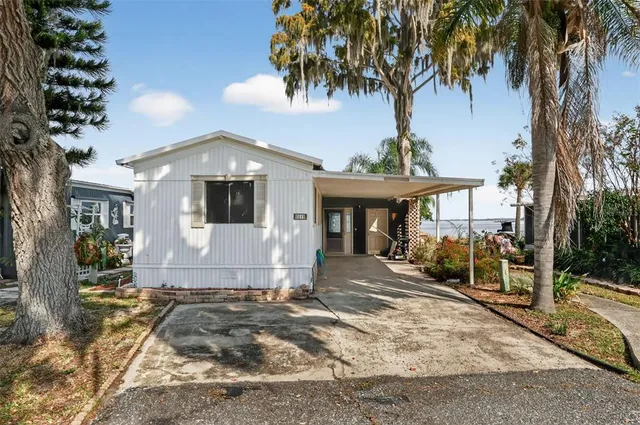 a front view of a house with a yard and potted plants