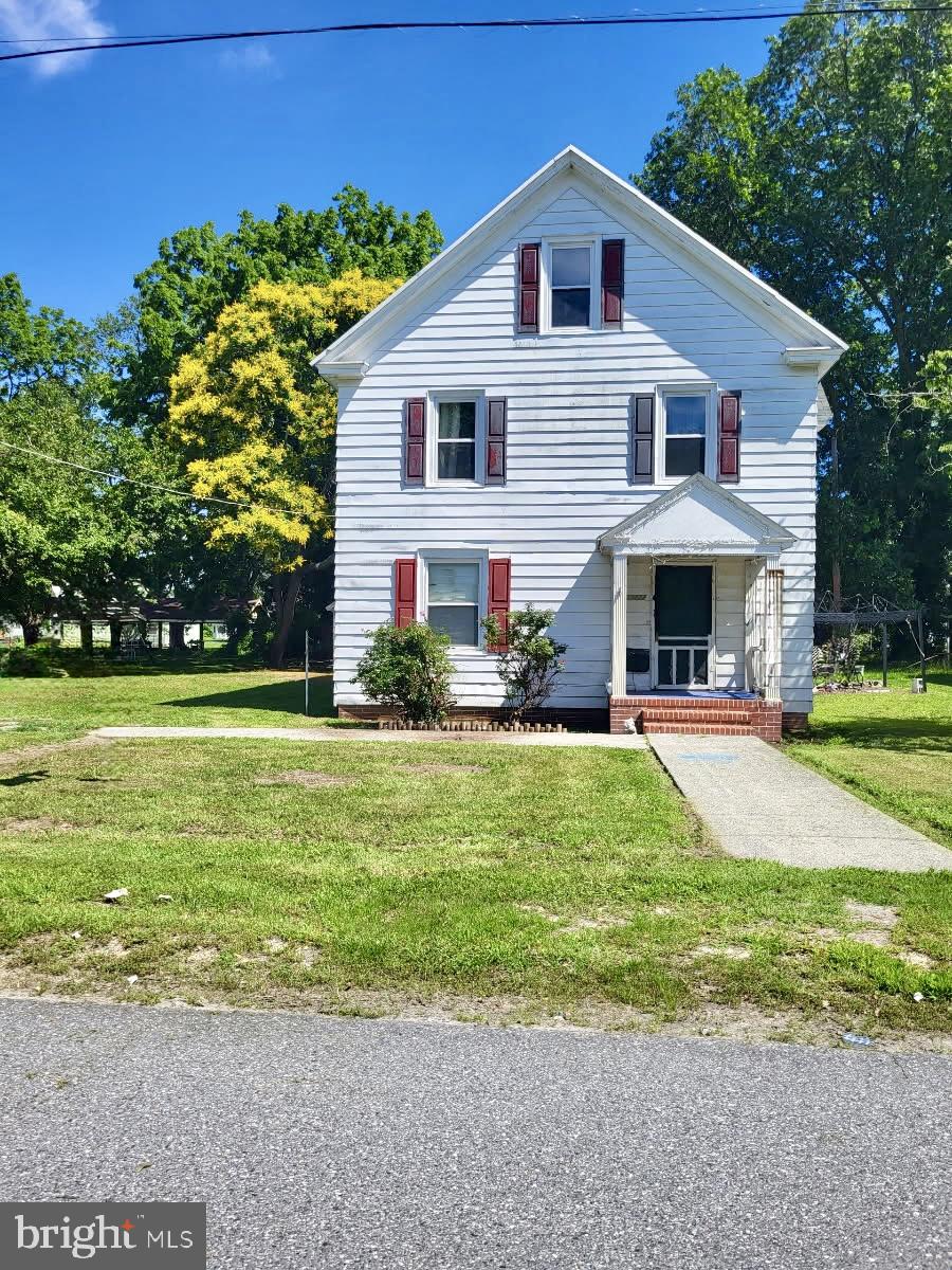 a view of a house with a yard and potted plants