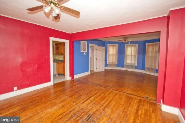a view of an empty room with a chandelier fan