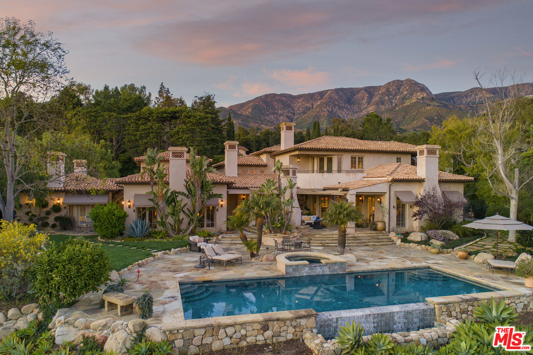 a view of a house with a yard and sitting area