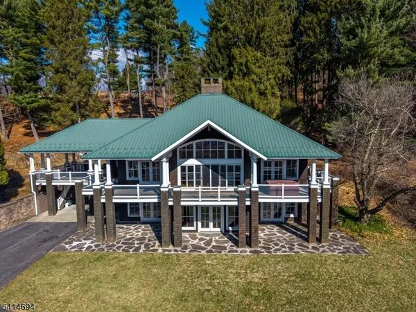 an aerial view of a house with swimming pool next to a yard