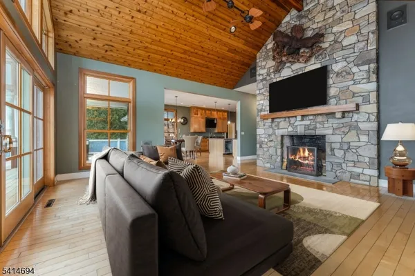 a view of an empty room with wooden floor fireplace and a window