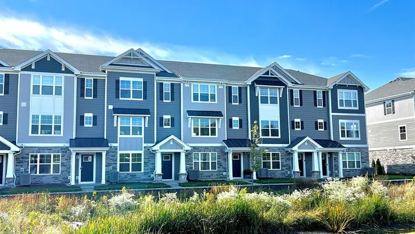 a front view of a residential apartment building with a yard and lake view