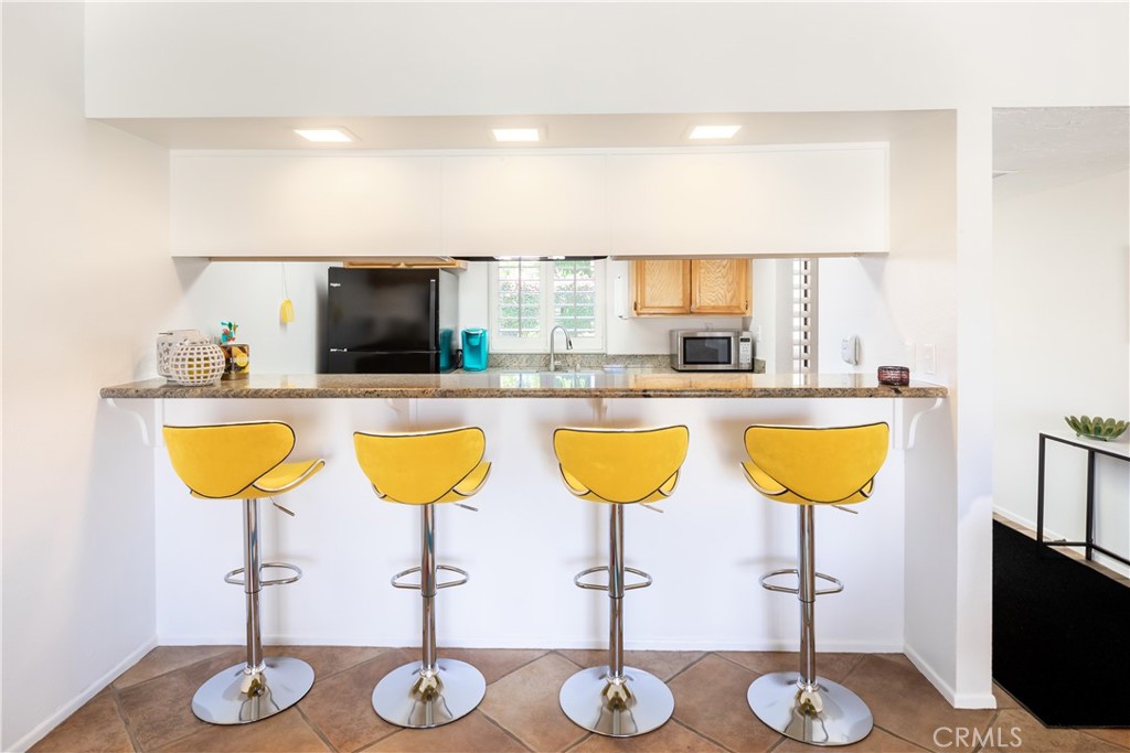 40657 Preston Trail Palm Desert, CA 92211 - Photo 30 of 46 a kitchen with stainless steel appliances kitchen island granite countertop a table and chairs
