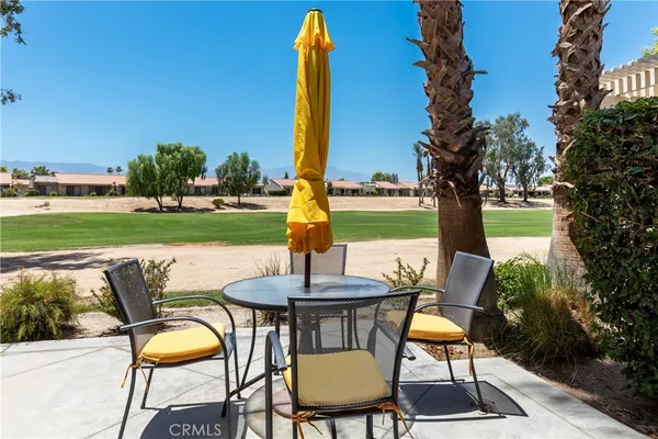 a view of a chairs and table in patio with a backyard