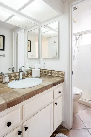 a bathroom with a granite countertop sink a toilet and a mirror