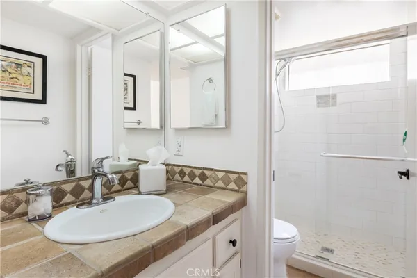 a bathroom with a granite countertop sink toilet and shower