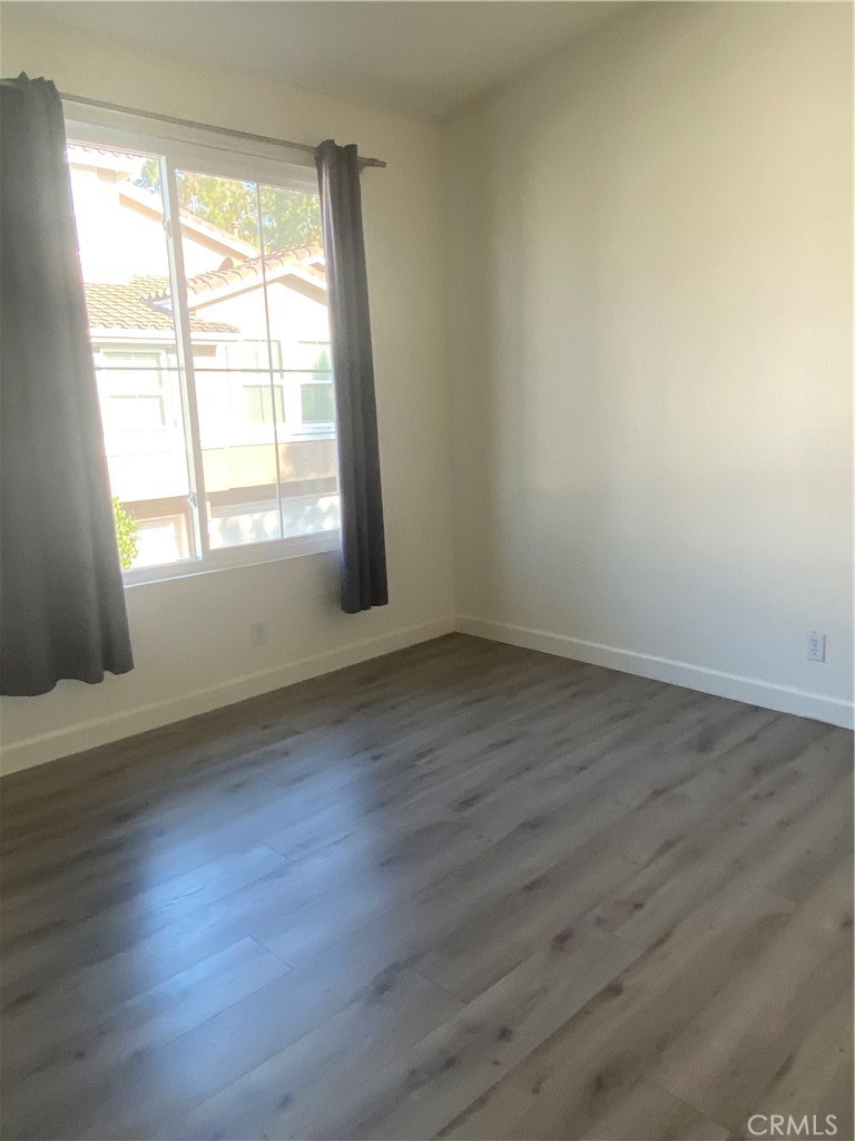 3301 Orangewood Irvine, CA 92618 - Photo 8 of 10 an empty room with wooden floor and windows