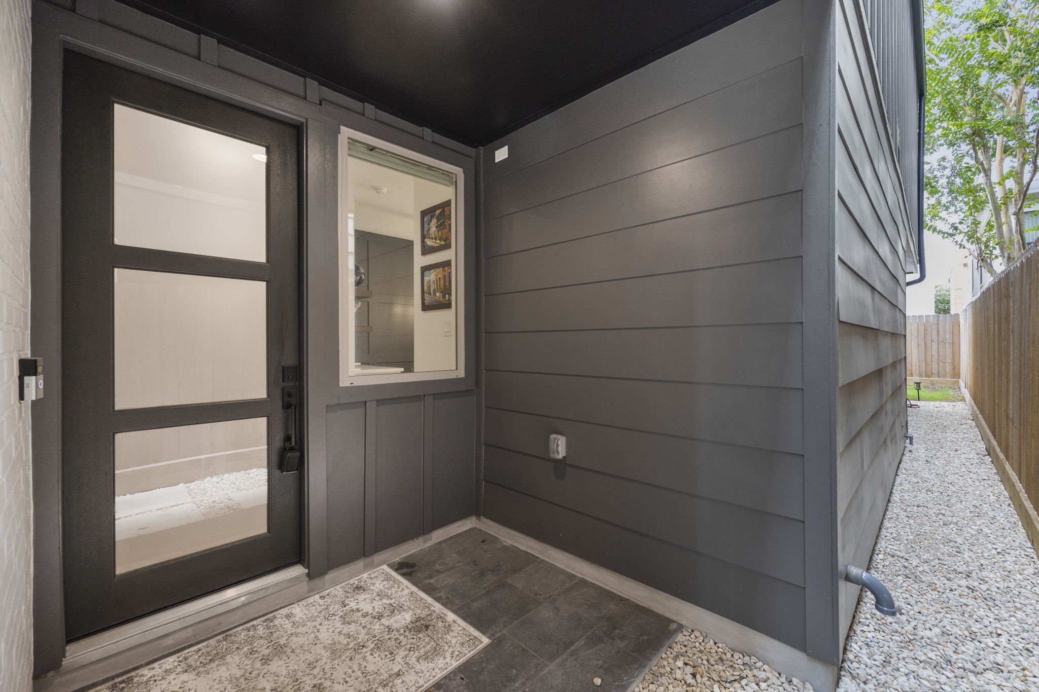 2411 Hazard Street Houston, TX 77019 - Photo 7 of 46 This private front entryway welcomes you with sleek modern finishes, a stylish black front door with glass inserts, and convenient side access. The minimalist design is complemented by a durable stone floor, creating an inviting yet low-maintenance entrance to the home.