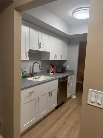 a kitchen with granite countertop white cabinets and white appliances