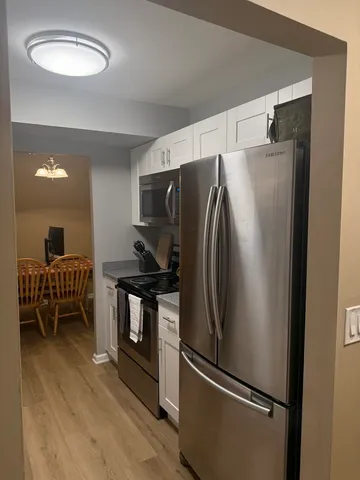 a metallic refrigerator freezer sitting in a kitchen