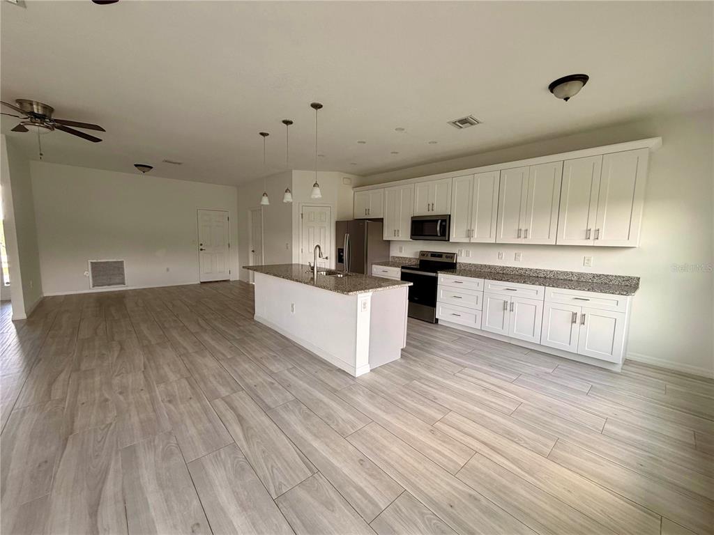 14142 Appleton Boulevard Port Charlotte, FL 33981 - Photo 8 of 26 a large kitchen with cabinets and wooden floor