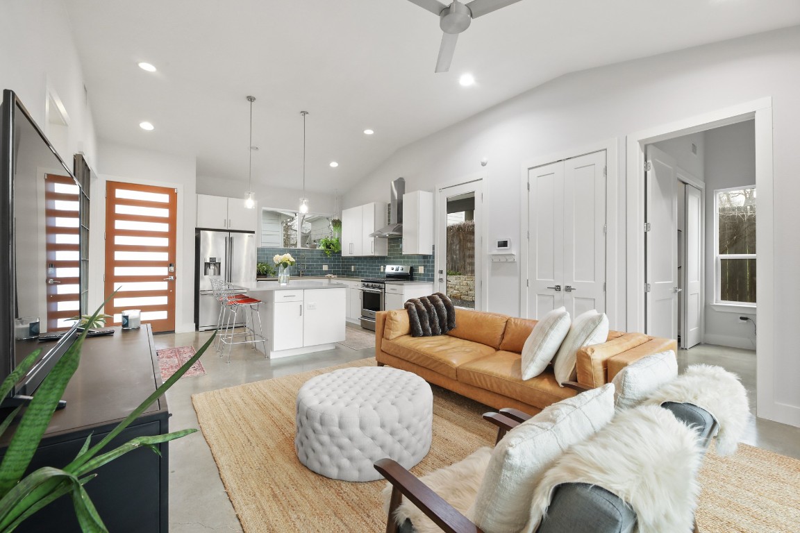 a living room with furniture kitchen and a large window