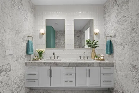 a bathroom with double sink and a mirror