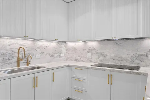 a kitchen with granite countertop white cabinets and a sink