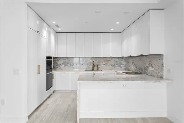 a kitchen with stainless steel appliances granite countertop a sink stove and cabinets