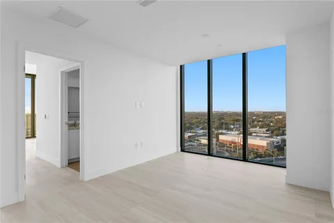 wooden floor in an empty room with windows and city view