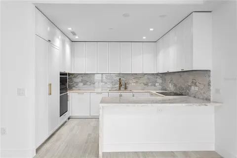 a kitchen with stainless steel appliances granite countertop a sink stove and cabinets