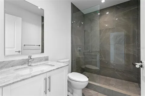 a bathroom with a sink toilet a mirror and shower