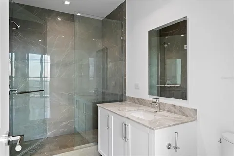 a bathroom with a granite countertop sink a shower and a mirror